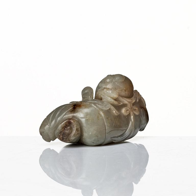 A neprite sculpture of a reclining boy with a duck, late Qing dynasty.