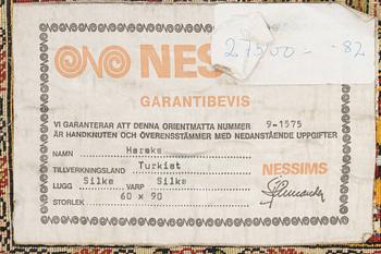 A silke rug, Hereke, signed, c. 90 x 61 cm.
