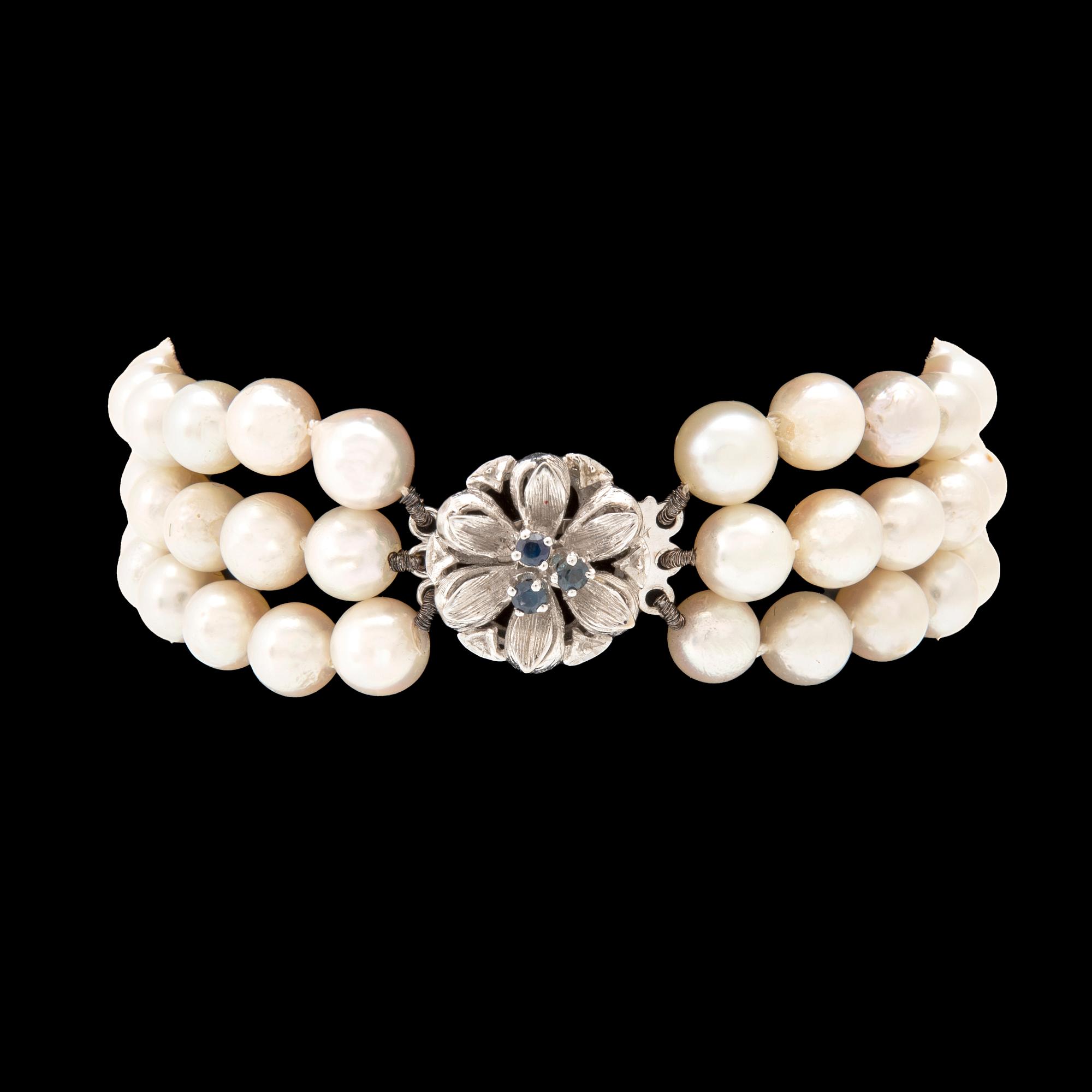 A three-row bracelet of cultured pearls and clasp in 18K white gold.