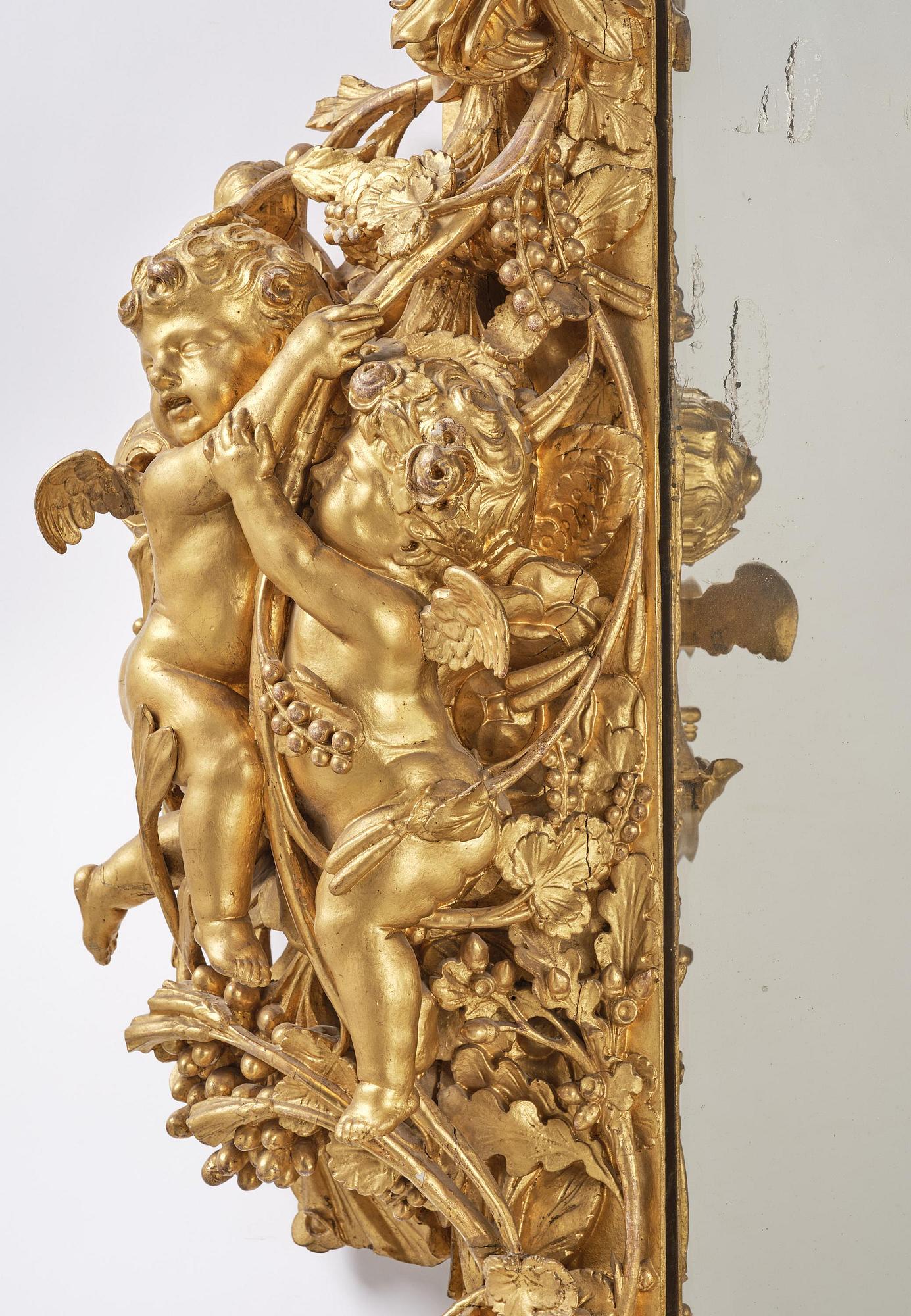 A presumably Dutch Louis XIV carved giltwood frame with mirror glass, in the style of Jean Le Pautre, late 17th century.
