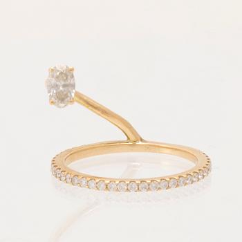 An 18K gold ring set with an oval cut and round brilliant cut diamonds by LWL Jewelry.