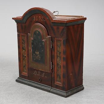 A painted pine wall cabinet, dated 1808.