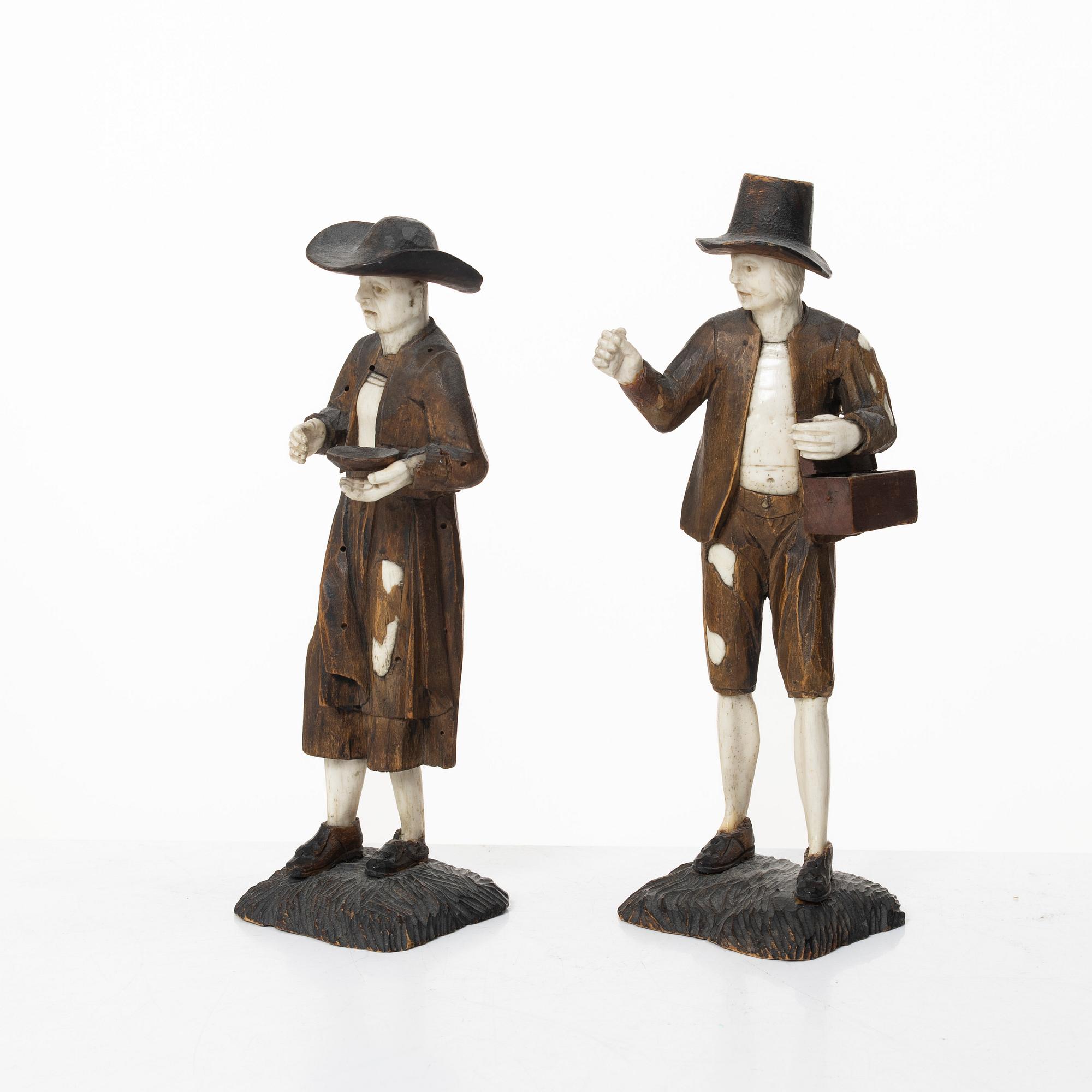 A pair of German carved bone and limewood figures by a follower of Simon Troger, early 18th century.
