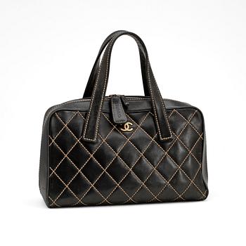 612. CHANEL, a black leather bag with beige stitching.