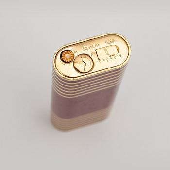 CARTIER, a red and gold lacquer lighter.