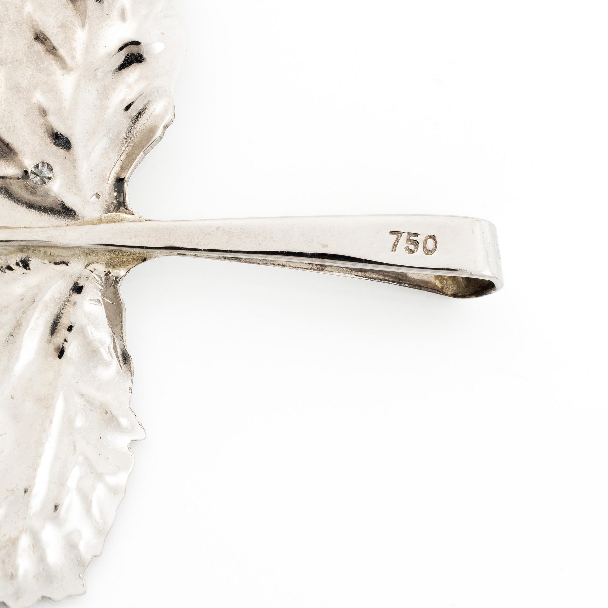 Brooch/pendant in the shape of a leaf, 18K white gold set with brilliant-cut diamonds and an emerald.