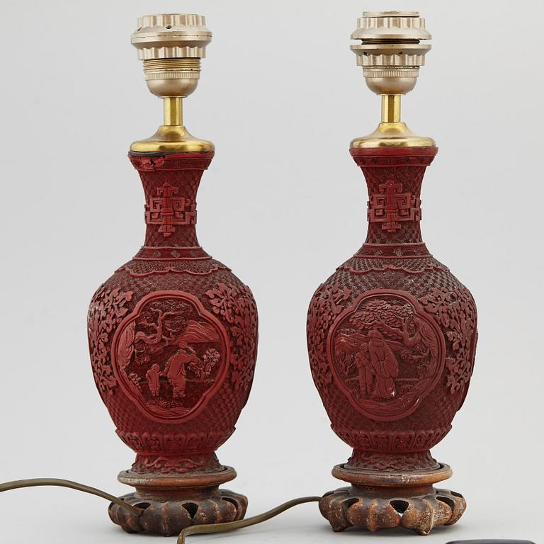 A pair of Chinese red lacquered vases, turned into table lamps, 20th century.