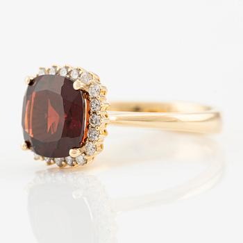 Ring in 18K gold with a faceted garnet and round brilliant-cut diamonds.