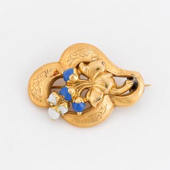 A blue and white emamelled brooch with a floral motif.