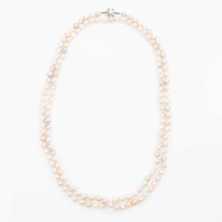 Long cultured pearl necklace with an 18K white gold clasp set with emeralds.