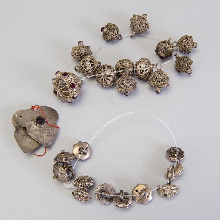 A collection of mostly silver, tradition folk buttons and belt buckles.