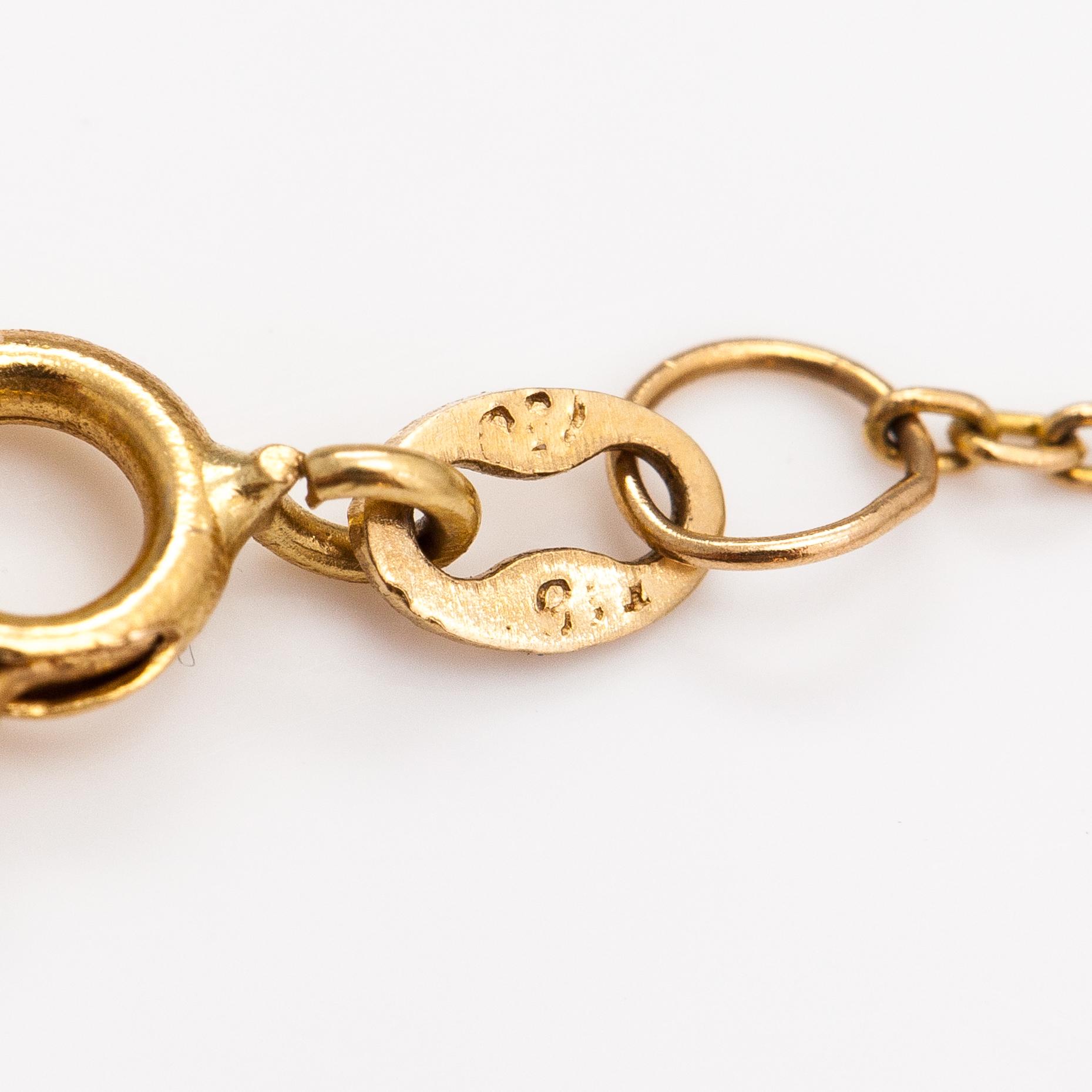 A 14K and 18K gold necklace with an ca. 2.22 ct emerald and a ca. 0.05 ct diamond.