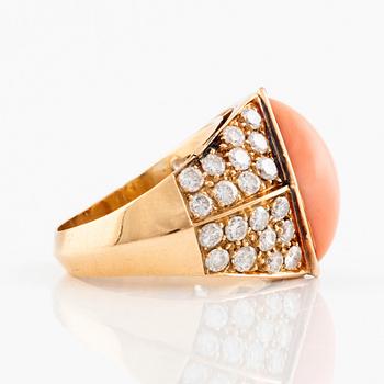 An 18K gold and coral ring set with round brilliant-cut diamonds.