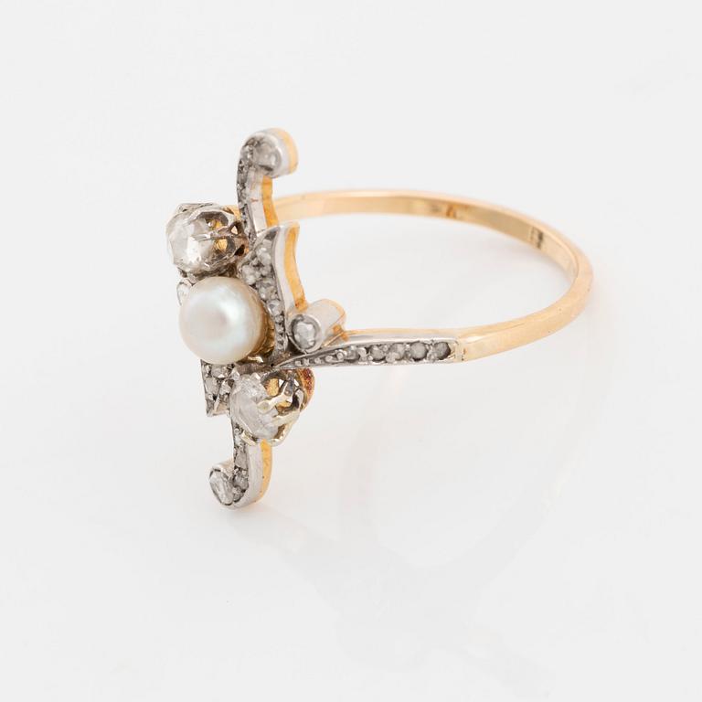 A platinum and gold ring set with a pearl and rose-cut diamonds.