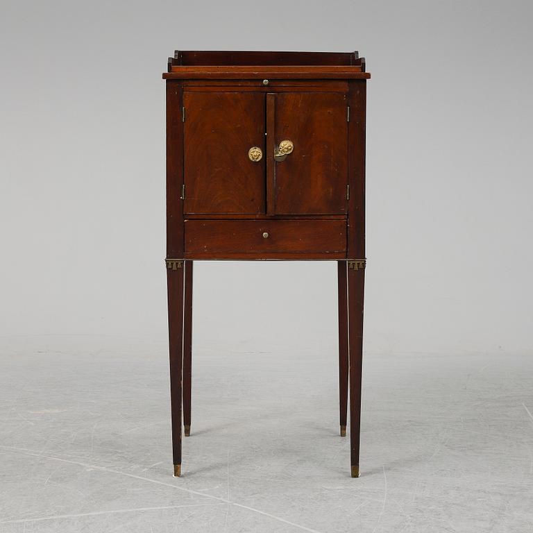 A first half of the 19th century mahogany veneered bedside table.