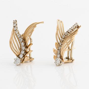 A pair of 18K gold earrings with round brilliant-cut diamonds.