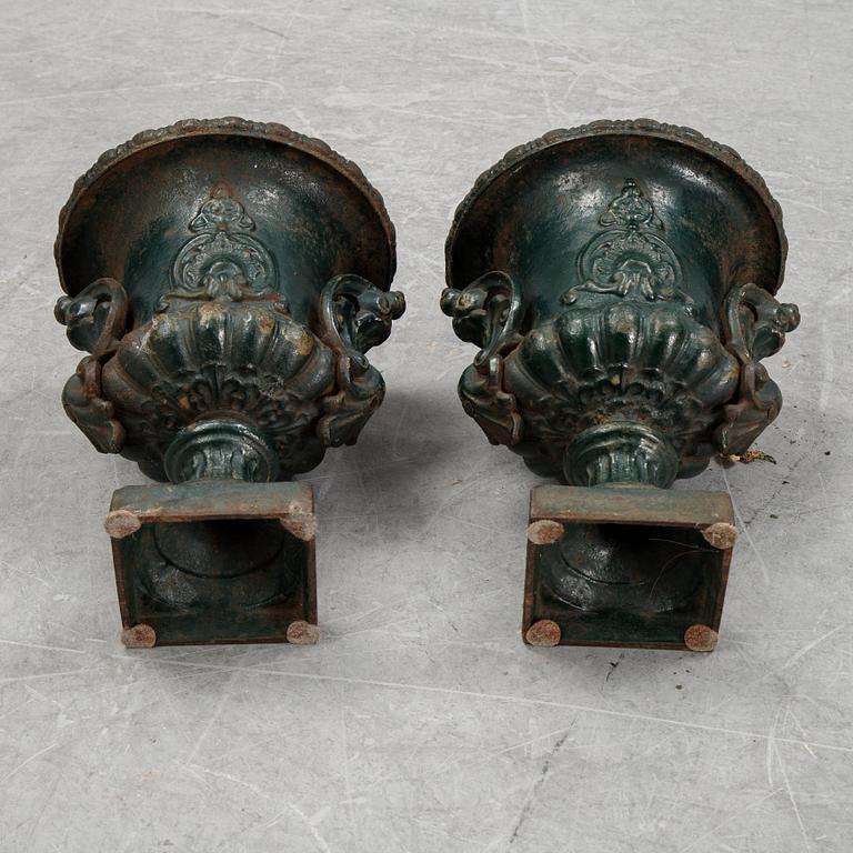 A pair of cast iron garden urns.