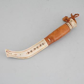 A Sami knife in antler, birch and leather, signed PU, carved dating 1975.