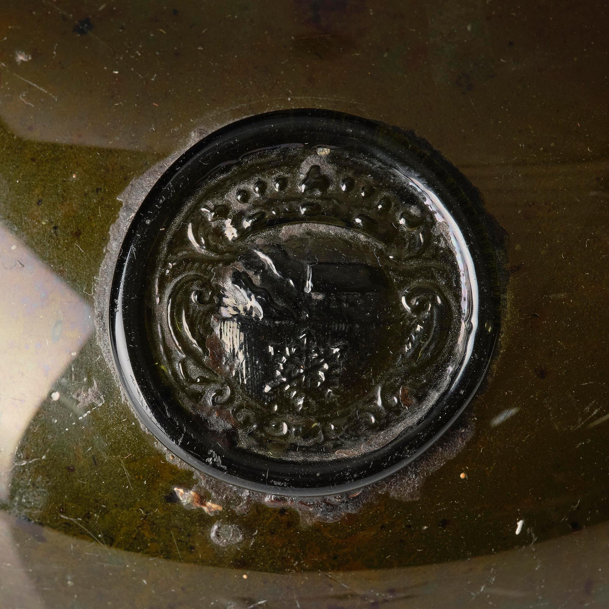 A large armorial wine bottle, Skånska glass manufactory, Henrikstorp, 18th century.