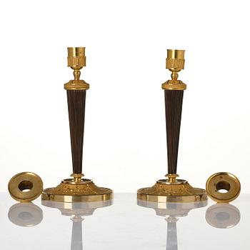 A pair of Empire ormolu and patinated bronze candlesticks.