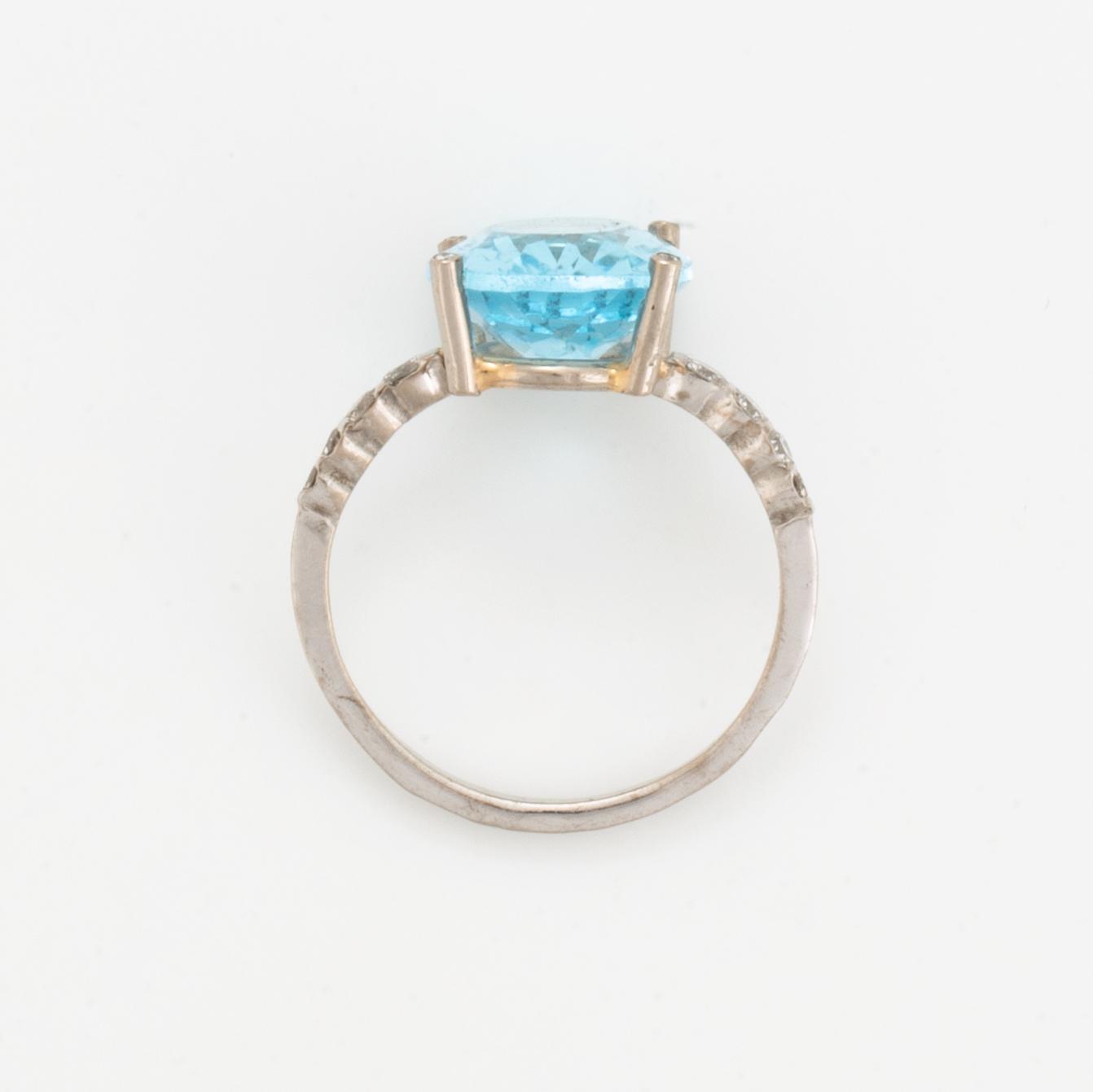 Oval faceted blue topaz and brilliant-cut diamond cocktail ring.
