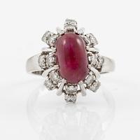 Ring 18K guld med en cabochonslipad rubin och runda briljantslipade diamanter.