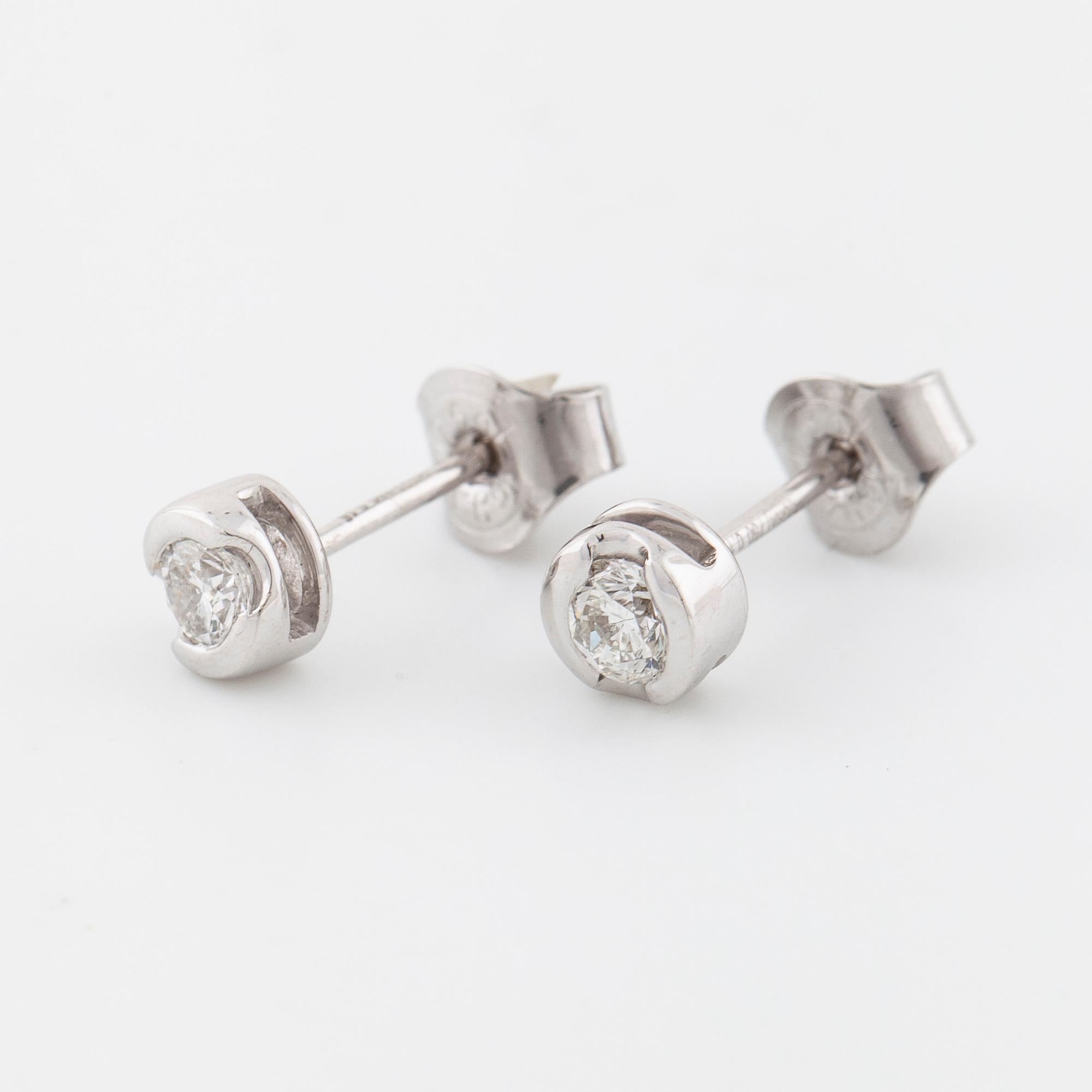 A pair of brilliant cut diamond earrings.