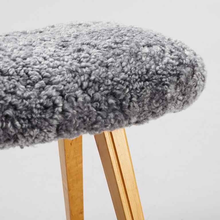 A birch stool with new sheepskin upholstery.