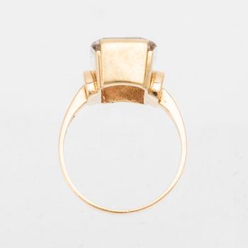 An 18K gold ring set with a step-cut synthetic white spinel.