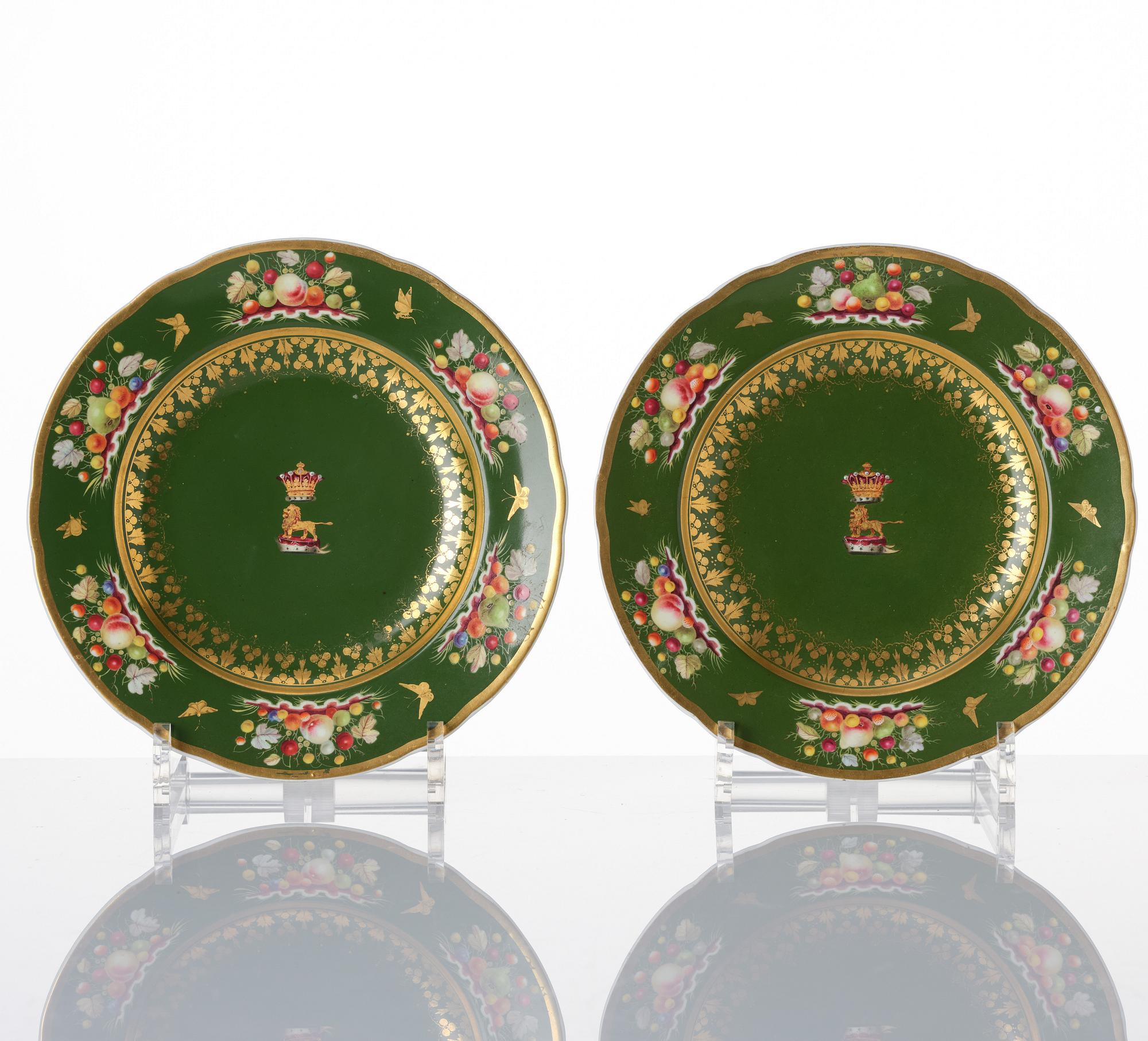 A pair of armorial butter tureens with covers and stands and two fruit dishes, Derby, England, circa 1830.