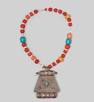 698. A silvered copper alloy pendant with beads, Tibet, late 19th Century.