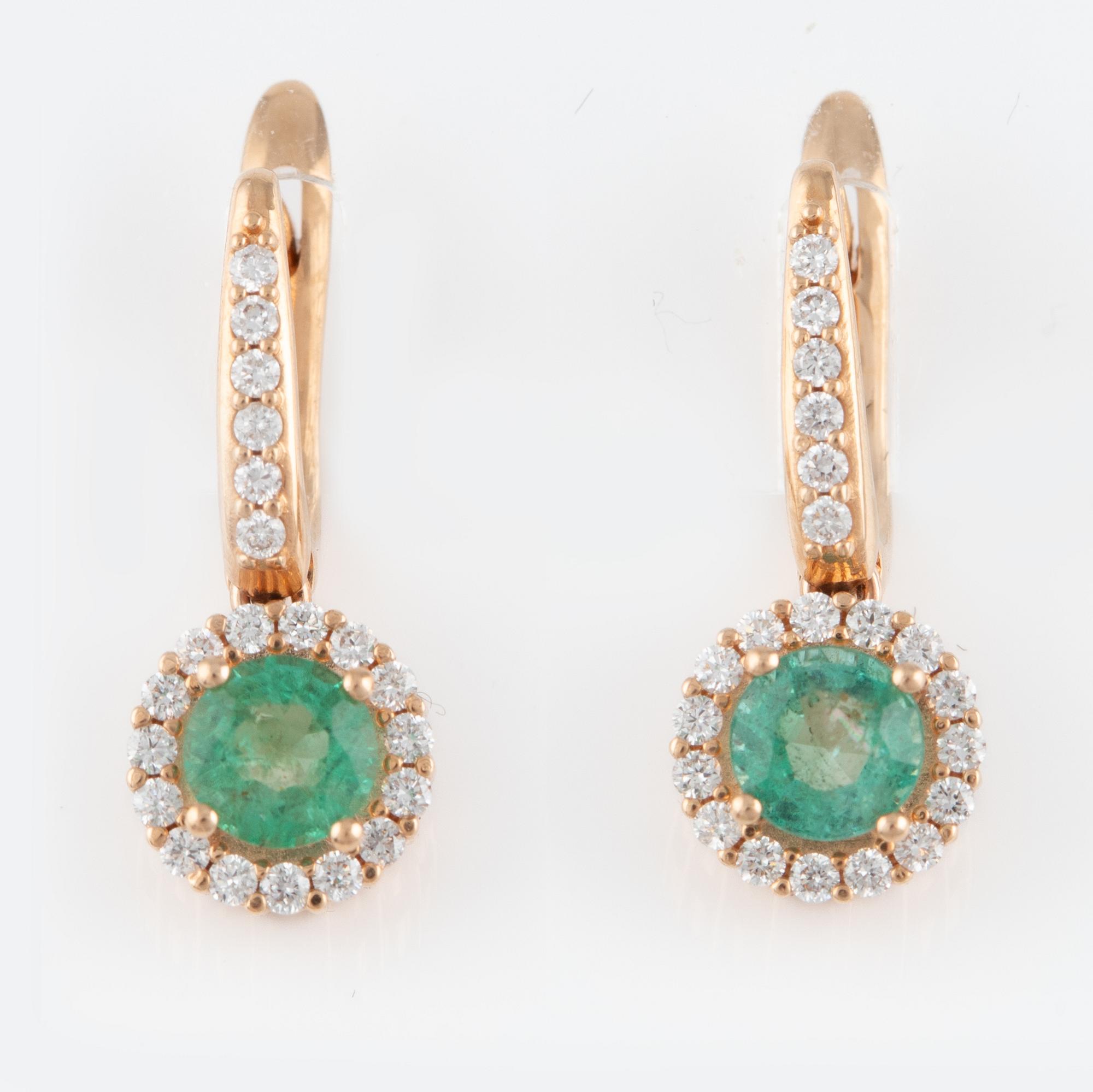 Ett par örhängen med fasettslipade smaragder och runda briljantslipade diamanter.