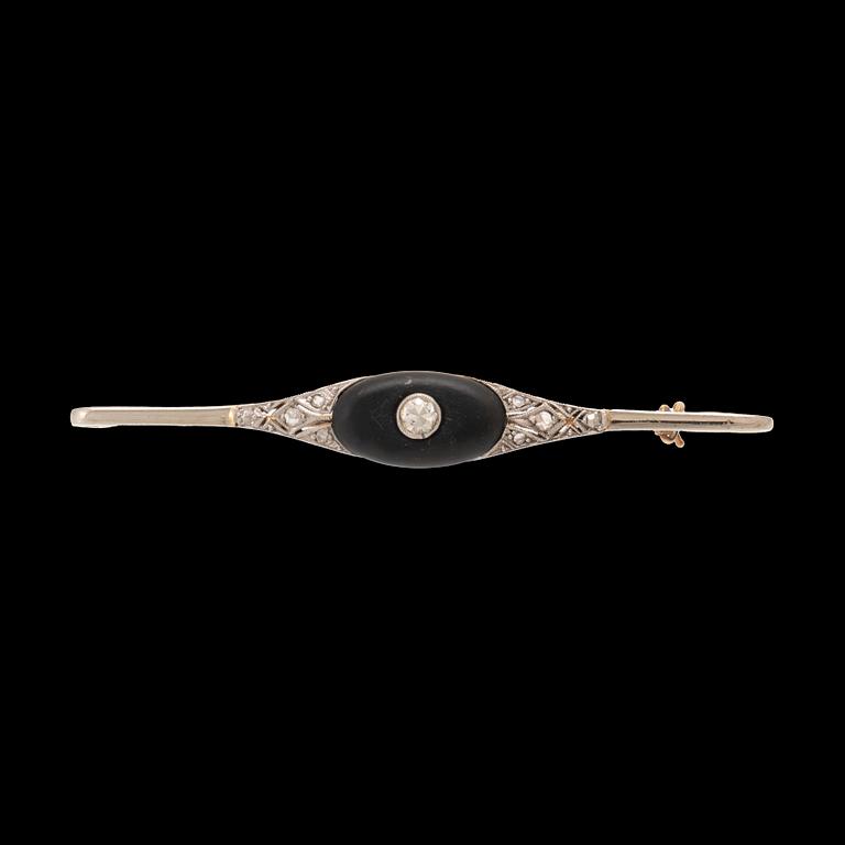A 14K white and red gold brooch set with round brilliant-cut and rose-cut diamonds and a black stone.