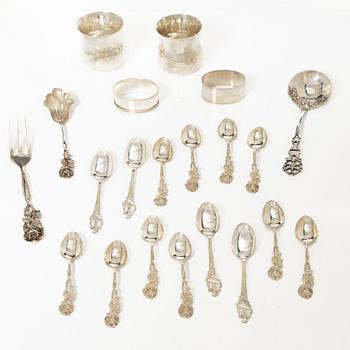 A pair of beakers, two napkin rings, and 17 pieces of cutlery, silver.