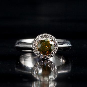 RING, 18K vitguld, briljantslipad diamant 1,11 ct. 16 st. diamanter tot. 0,22 ct. Vikt 8,8 g. Intyg.