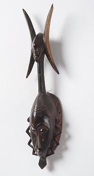 A sculptue and two masks reportedly from The Ivory coast, from the second half of the 20:th century.