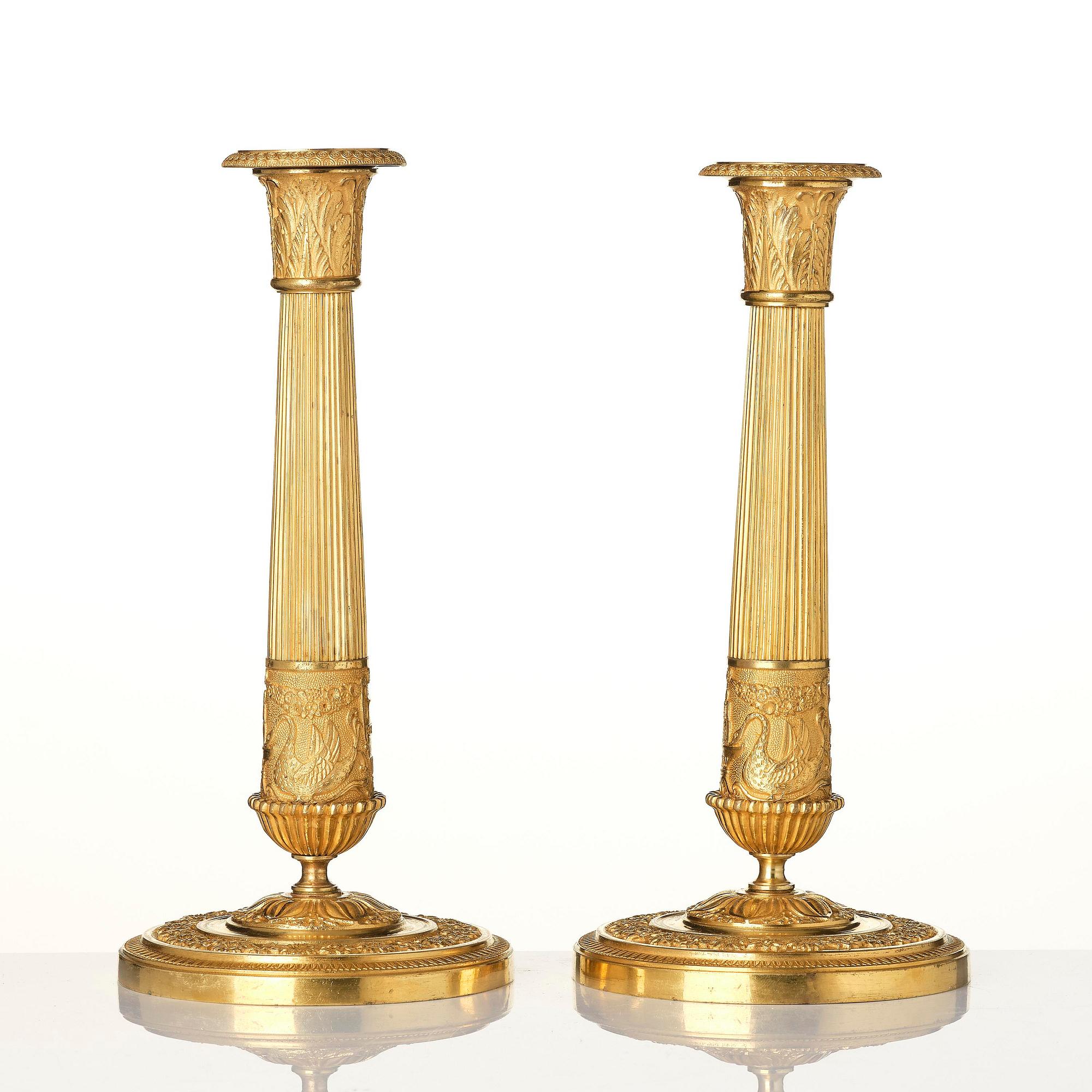 A pair of French Empire ormolu candlesticks, early 19th century.