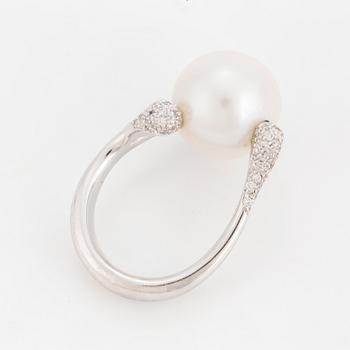 A ring set with a cultured 'South Sea' pearl and round, brilliant-cut diamonds.