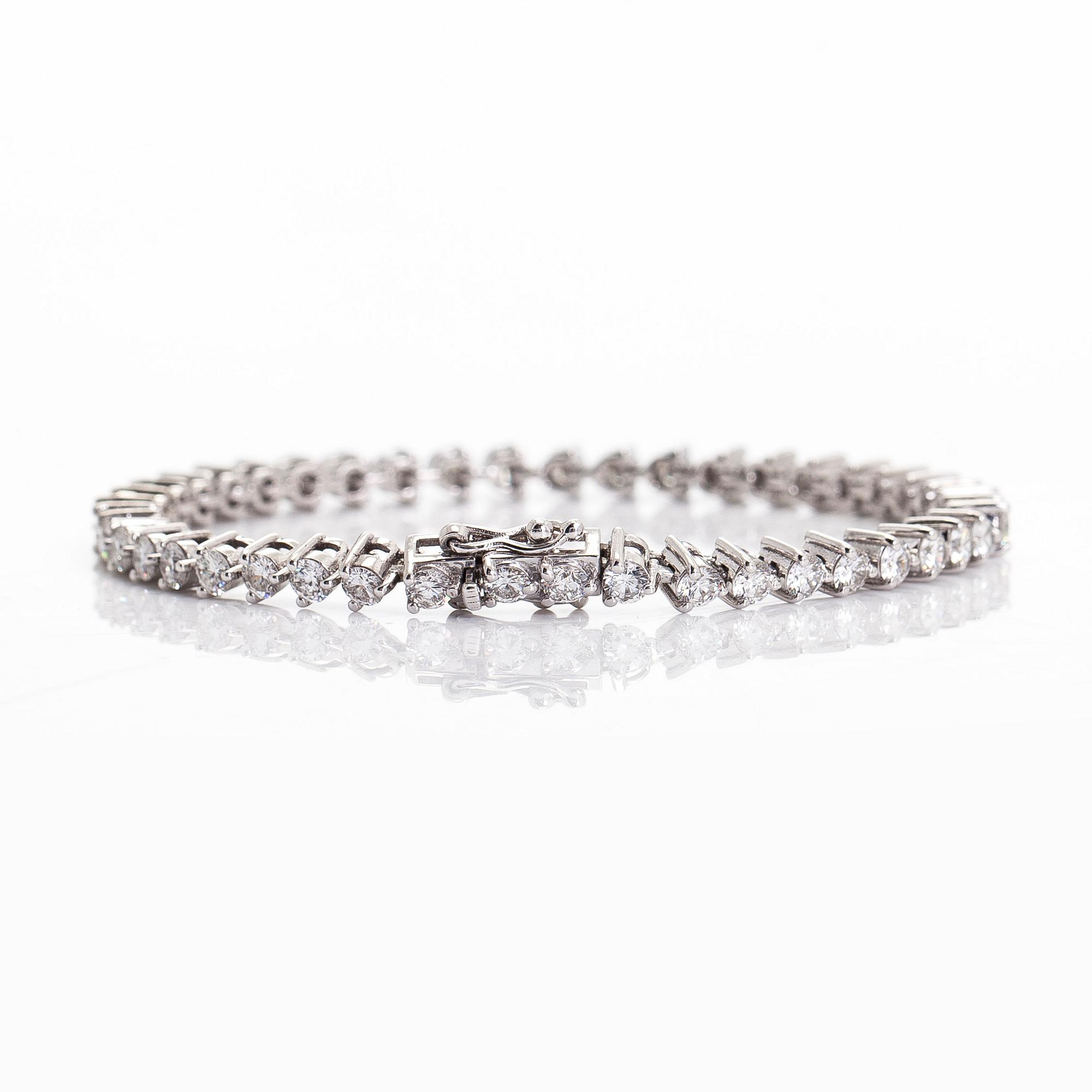 An 18K white gold tennis bracelet, with brilliant-cut diamonds.