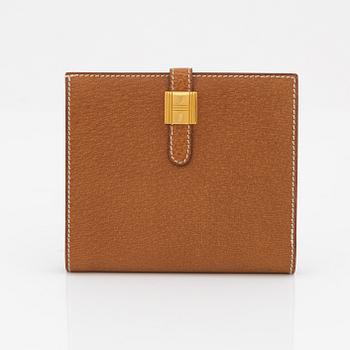 Hermès, a brown leather gold lock wallet.