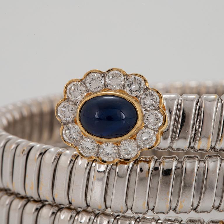 An 18K gold bangle set with cabochon-cut sapphires and round brilliant-cut diamonds.