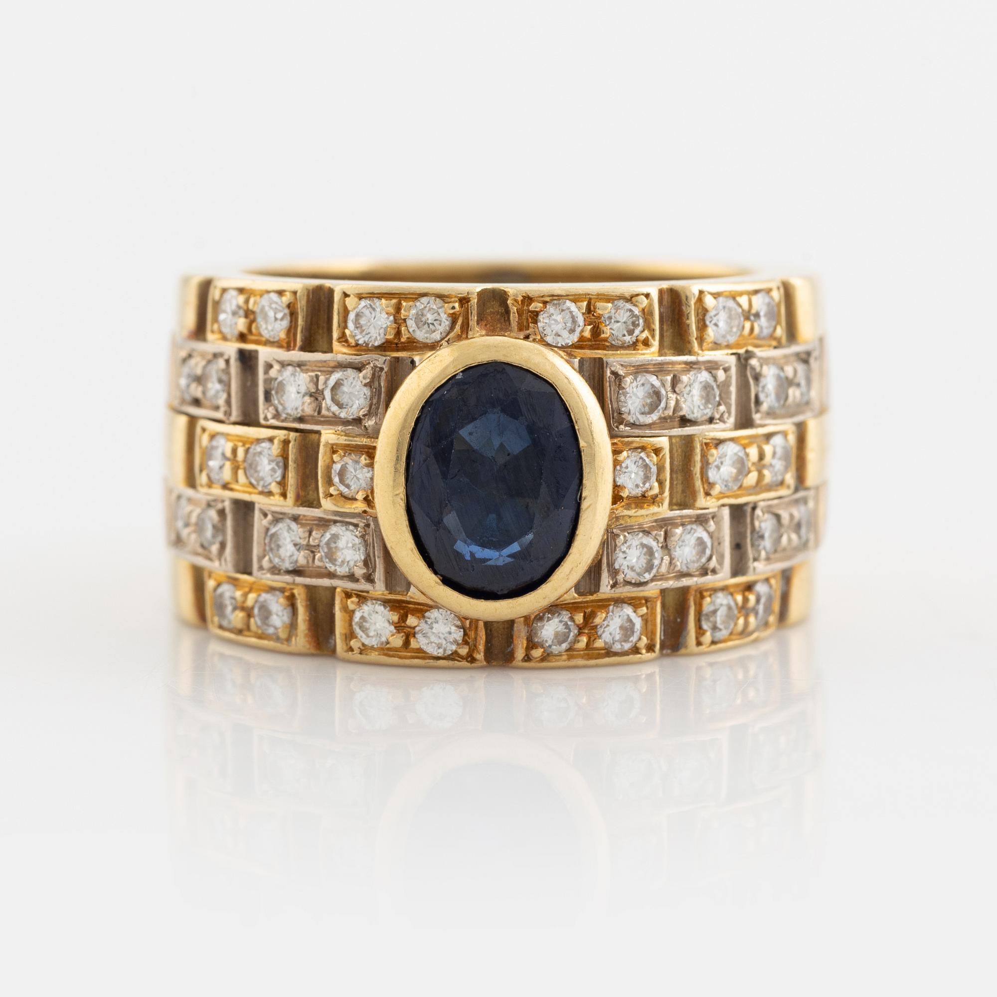 Ring 18K guld med en fasettslipad safir och runda briljantslipade diamanter.