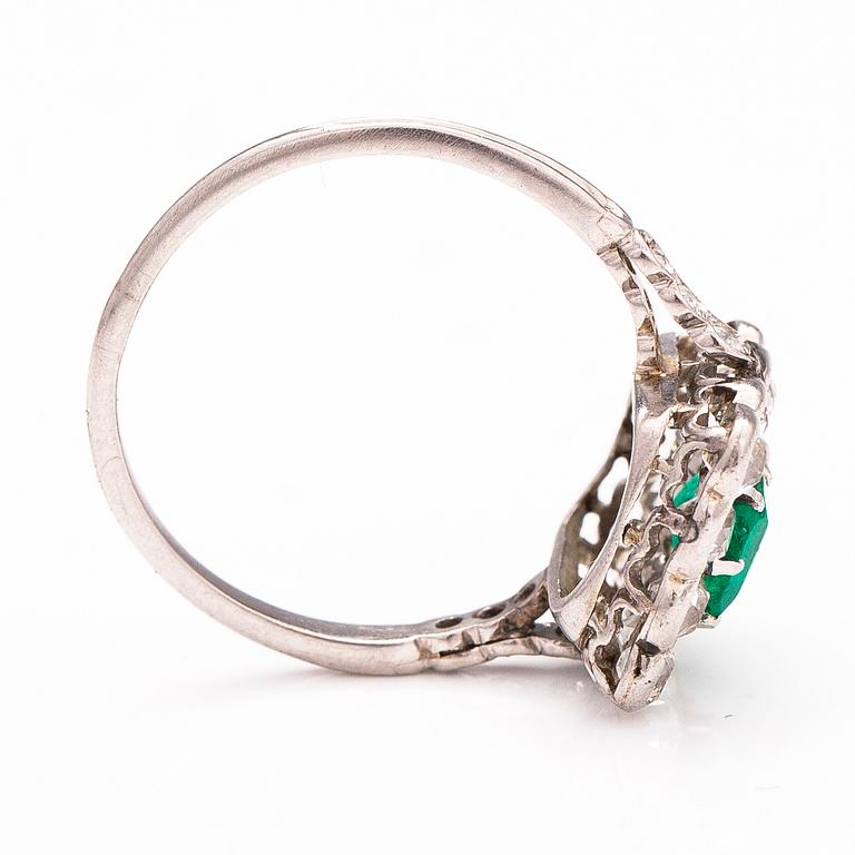 A platinum ring with an emerald ca 0.71 ct and old cut diamonds ca 1.66 ct in total.