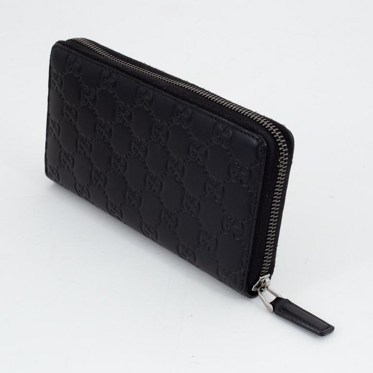 Gucci, an embossed böack leather wallet.