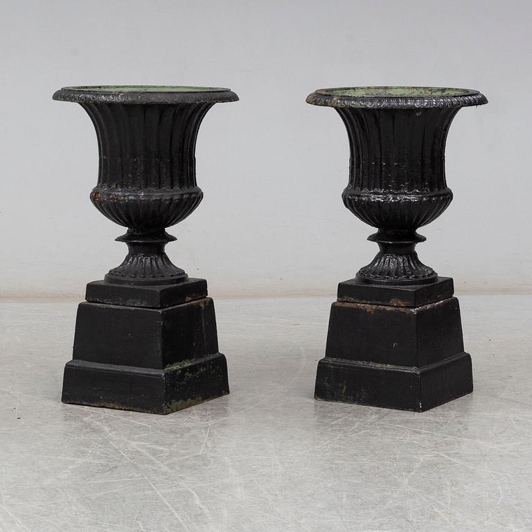 A pair of 20th century cast iron urns.