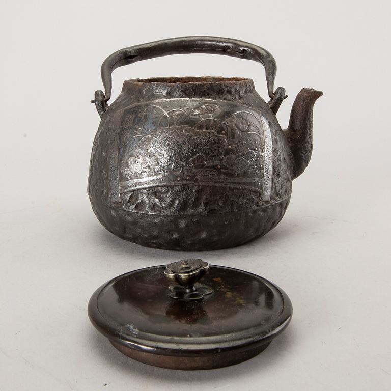 A Japanese iron tea pot with bronze cover, signed.