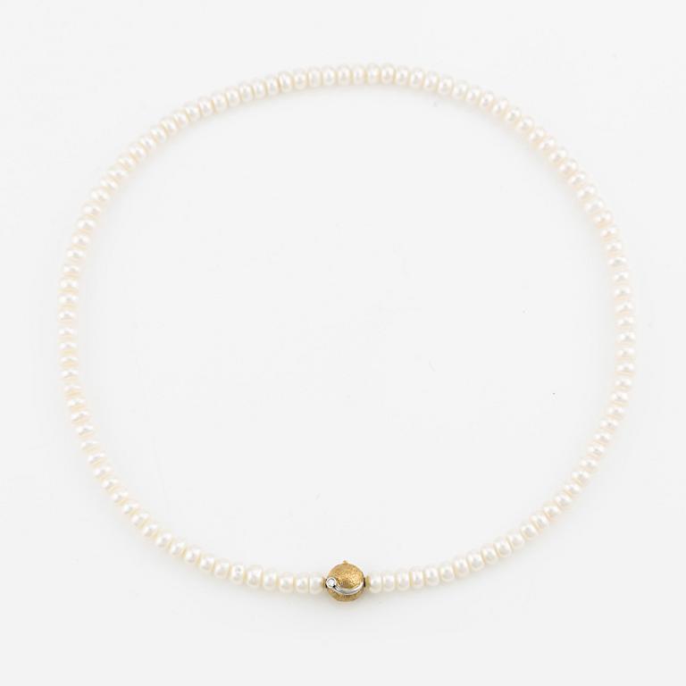 Ole Lynggaard clasp in 18K gold with a round brilliant-cut diamond and a freshwater cultured pearl necklace.