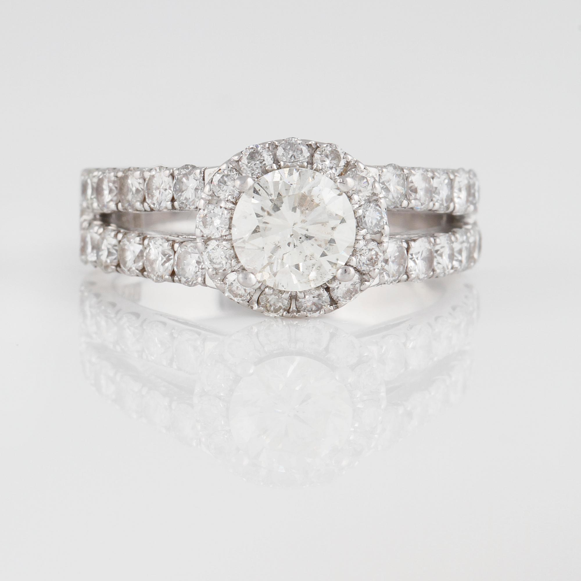 RING, 18K vitguld med briljantslipad diamant ca 0.80 ct samt små briljantslipade diamanter ca 6.30 ct. Vikt 6,3 gram.