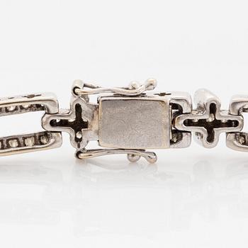 An 18K white gold bracelet set with round brilliant-cut diamonds.