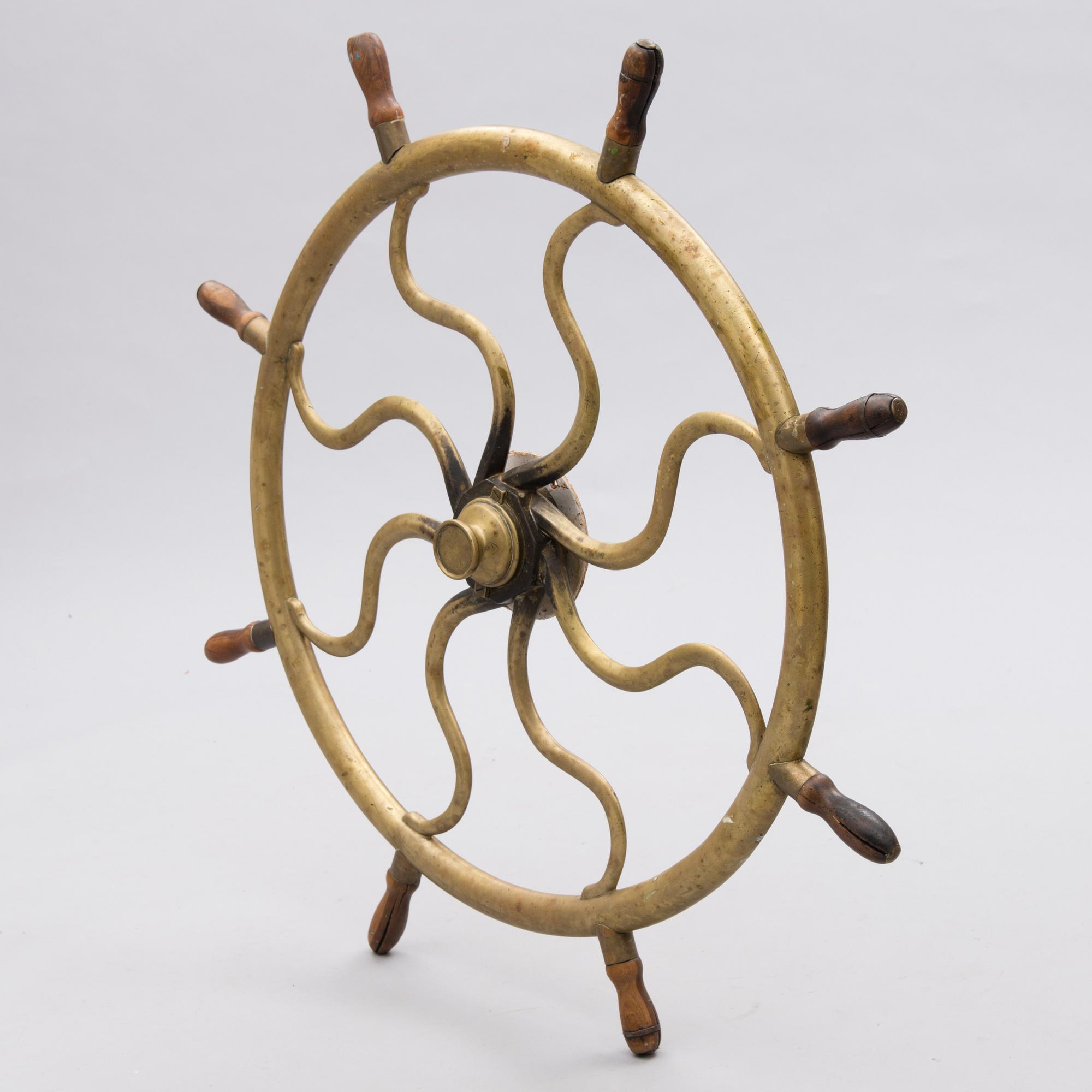 A ship's brass steering wheel, circa 1900.